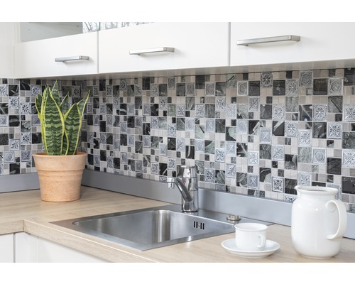 Kuchyňská scéna s dřezem, mozaikovými dlaždicemi a rostlinou