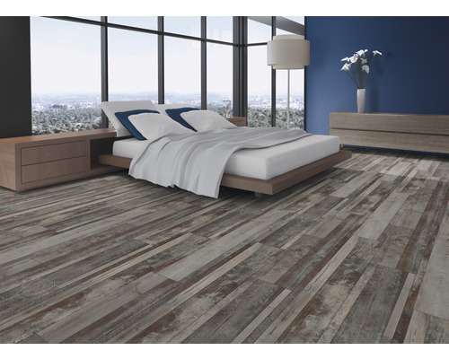 Ložnice s dřevěnou podlahou se vzhledem prken, postelí, nočním stolkem a komodou