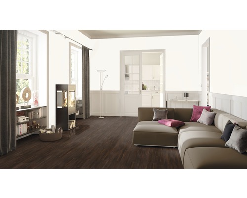 Obývací pokoj s pohovkou, kamny, knihovnou a dřevěnou podlahou.