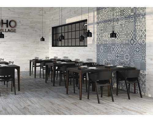 Interiér restaurace s dřevěnou podlahou, dřevěným obložením stěn a stěnou s dekoracemi