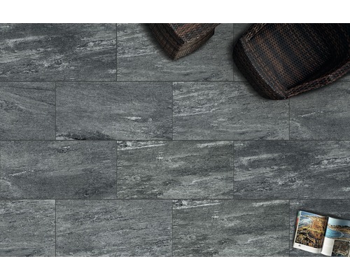 Pohled na podlahu s šedými dlaždicemi a dvěma ratanovými křesly