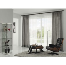 Obývací pokoj s vitrínou, závěsy, křeslem a kobercem pro útulnou atmosféru