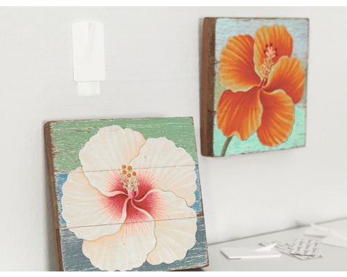 Dva dřevěné obrazy s květinovými motivy a upevňovací háček na zdi