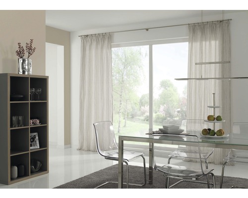 Světlá jídelna s jídelním stolem, transparentními židlemi, regálem a závěsy