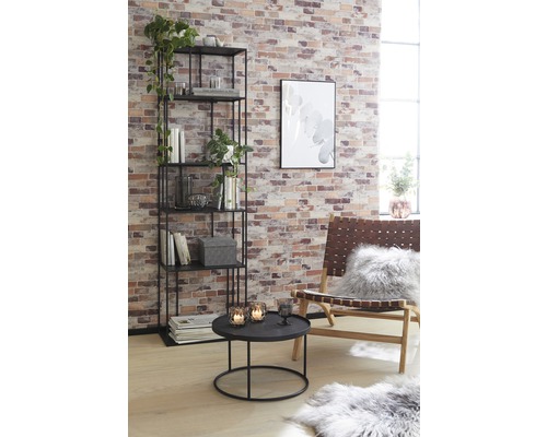 Obývací pokoj s regálem, stolem a křeslem před cihlovou zdí