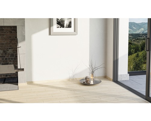 Světlá místnost s dlažbou, obrazem na zdi a výhledem do zeleně