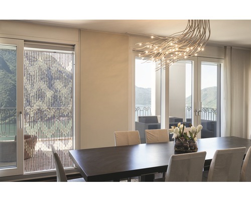 Jídelna s jídelním stolem, židlemi a bambusovou roletou před oknem s výhledem na jezero.