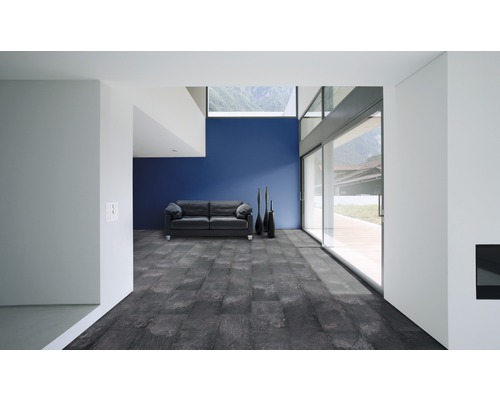 Světlá místnost s pohovkou, dlažbou a prosklenou stěnou