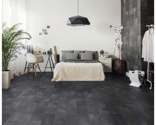 Ložnice s tmavou vinylovou podlahou s dřevěným vzhledem, postelí, stolem a pokojovou rostlinou