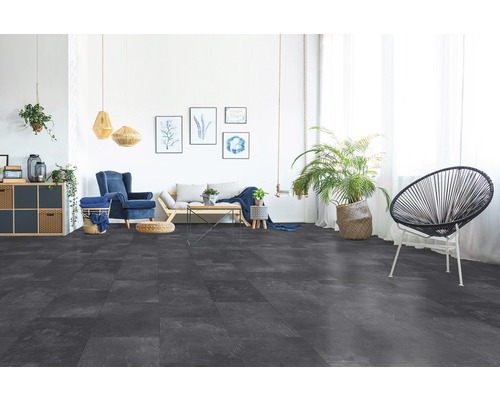 Obývací pokoj s šedou dlažbou, pohovkou, křeslem a dekorací