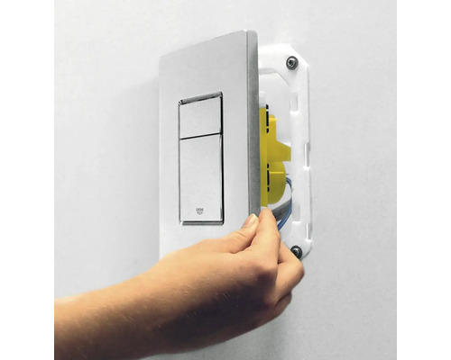 Ovládací tlačítko pro splachování toalety se montuje na zeď.