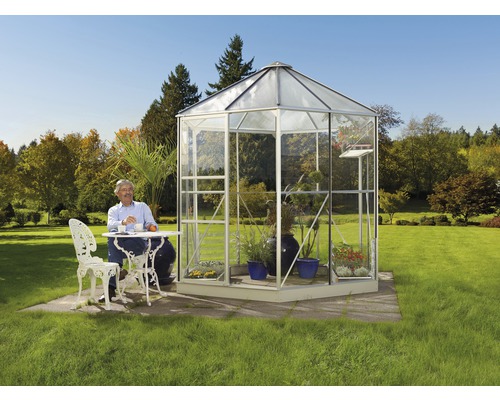 Volně stojící skleník s mužem u stolu