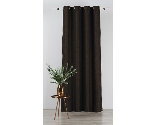 Ozdobné šály s oky na záclonové tyči vedle stolu s vázou květin.