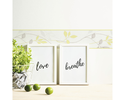 Nástěnná dekorace s bordurou, rámečky s nápisy láska a dýchat, hrnková rostlina a limetky