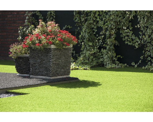 Zahradní prostor s umělým trávníkem, kamennými květináči a břečťanem