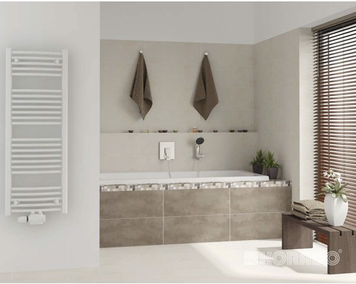 Koupelna s vanou, ručníky, radiátorem na ručníky a dřevěnými žaluziemi