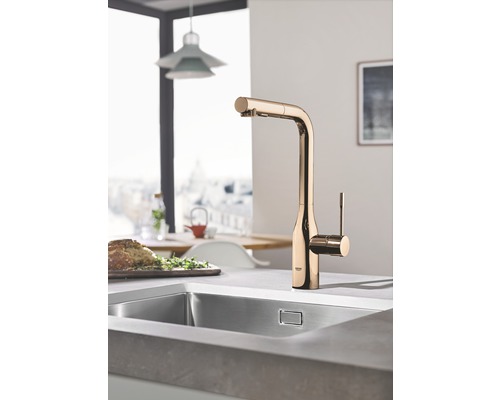 Kuchyňský dřez se zlatou baterií ve světlé kuchyni