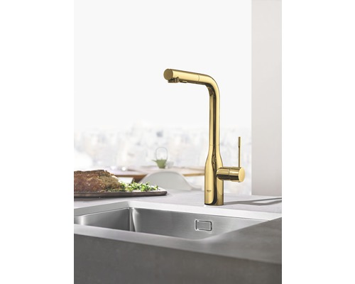 Kuchyňská scéna s dřezem a zlatou kuchyňskou baterií