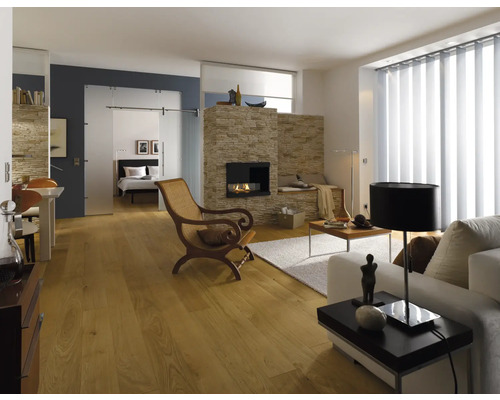 Světlý obývací pokoj s krbem, dřevěnou podlahou, gaučem, křeslem a posuvnými dveřmi do ložnice