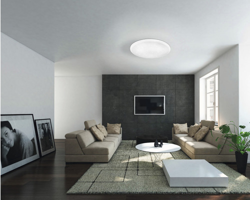 Obývací pokoj se stropním svítidlem, pohovkami, kobercem a televizí