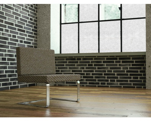 Scéna se židlí s kovovýma nohama před cihlovou zdí a oknem.