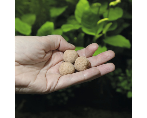 Tři hnojivé kuličky v ruce