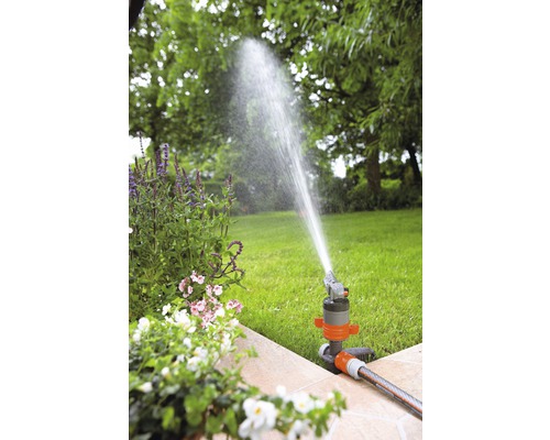 Zavlažování zahrady s trávníkovým postřikovačem na zahradě