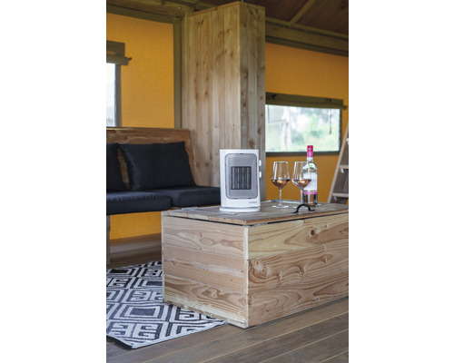 Interiér s dřevěným nábytkem, přenosným ohřívačem a dvěma sklenicemi vína na dřevěném stole