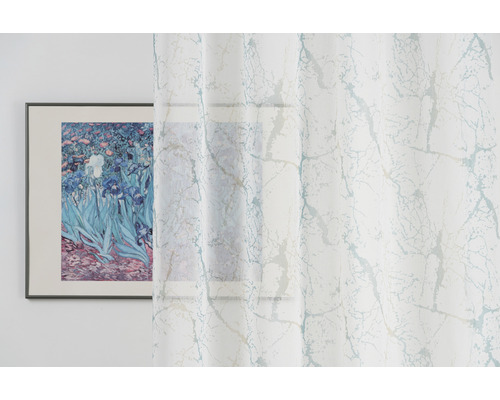 Dekorativní šály s mramorovým vzorem před oknem s orámovaným obrazem