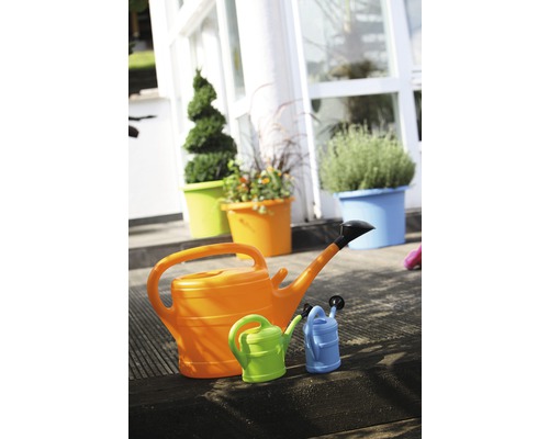 Tři konve různých velikostí před osázenými květináči