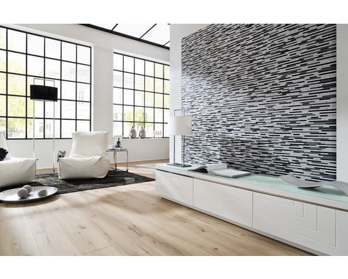 Světlá obývací místnost s parketovou podlahou, mozaikovou stěnou a velkými okny