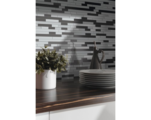 Stěna z mozaikových dlaždic nad kuchyňskou linkou s nádobím a dekorací