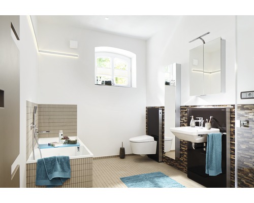 Světlá koupelna s vanou, toaletou, umyvadlem a zrcadlovou skříňkou