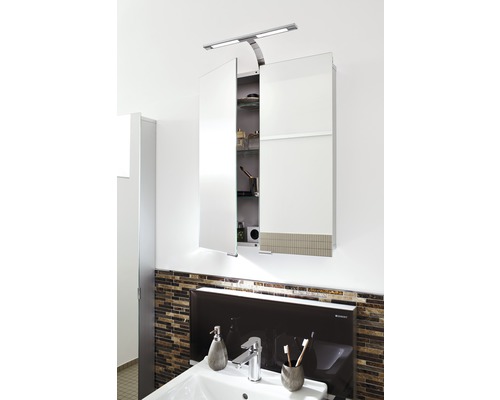 Zrcadlová skříňka s osvětlením nad umyvadlem v koupelně.