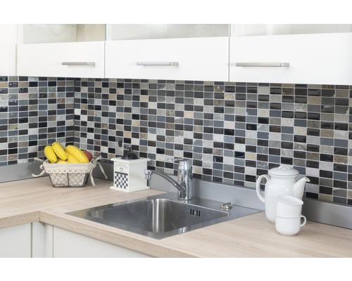 Kuchyňský dřez s vodovodní baterií, stěna s mozaikovými obklady, mlýnek na kávu a nádobí na pracovní desce.