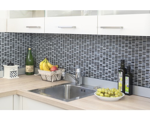 Kuchyňská scéna s dřezem, vodovodní baterií, mozaikovými obklady a kuchyňskými potřebami