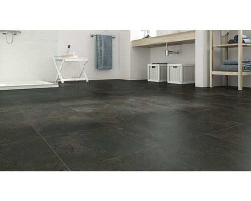 Koupelna s tmavou dlažbou, umyvadlem a sprchou.