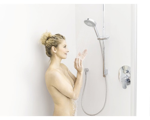 Žena ve sprše se sprchovou hlavicí a baterií