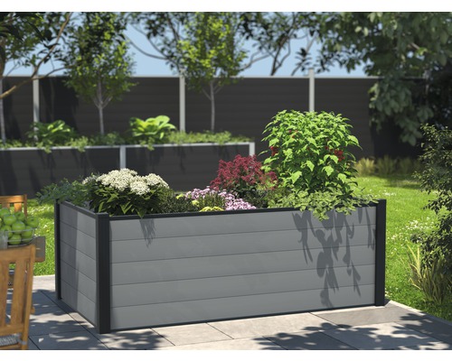 Plastový vyvýšený záhon s rostlinami na zahradě.