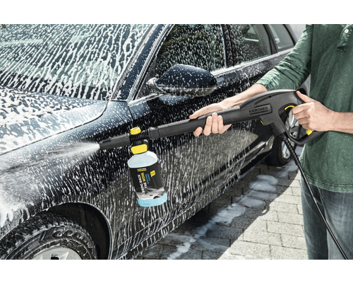 Osoba čistí auto pomocí vysokotlakého čističe Kärcher a čisticího prostředku.