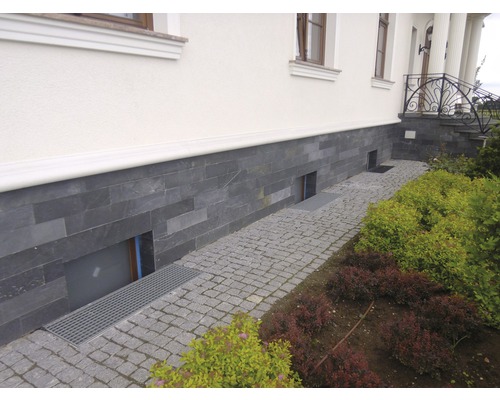 Exteriér domu s fasádou z přírodního kamene a dlážděnou cestou