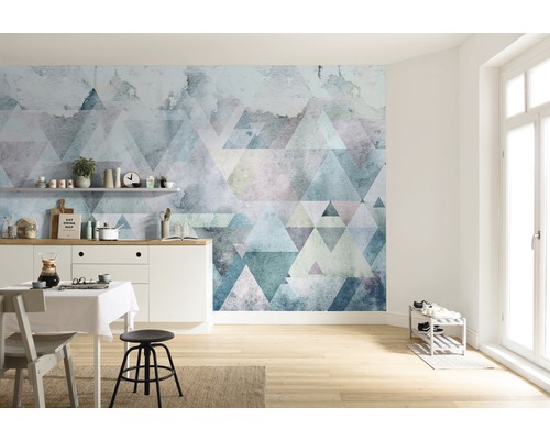 Světlá místnost s kuchyňským stolem a geometrickou tapetou s trojúhelníky