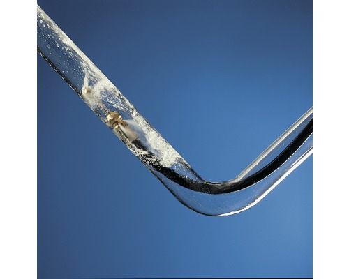 Průhledná trubice s vodou a malým zlatým předmětem