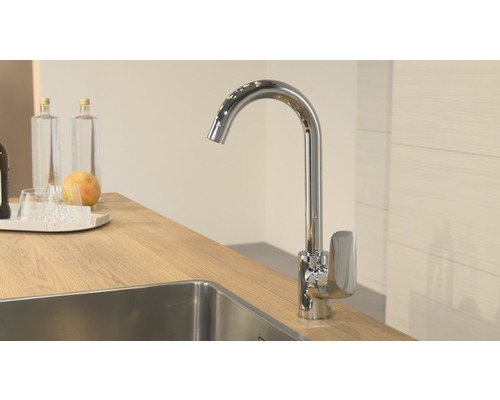 Kuchyňská vodovodní baterie z kovu u dřezu na pracovní desce