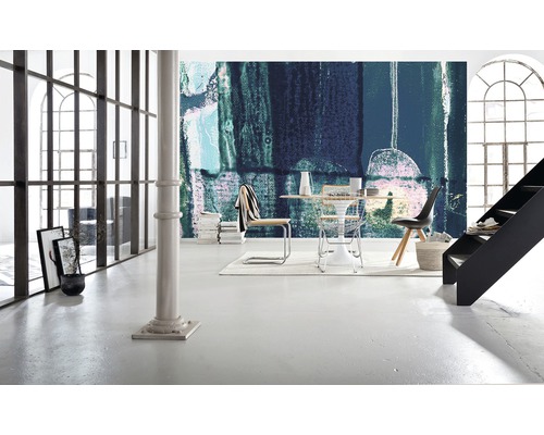 Světlá místnost s abstraktní tapetou, jídelním stolem a schodištěm