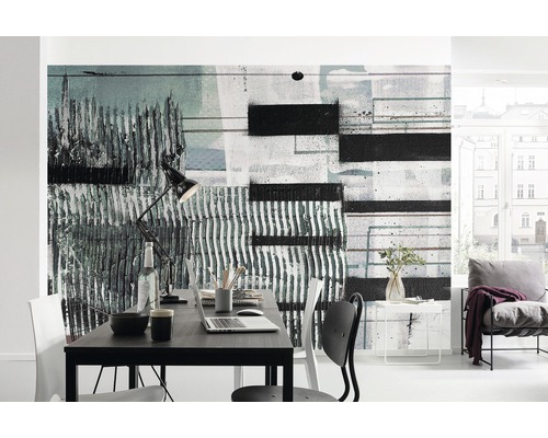 Moderní pracovna s abstraktní nástěnnou malbou, stolem a židlí.