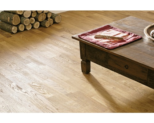 Interiér s dřevěnou podlahou, konferenčním stolkem a hromadou dřeva