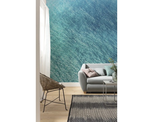 Obývací pokoj s fototapetou s motivem moře, pohovkou, křeslem a kobercem