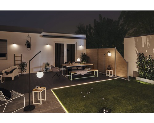 Osvětlená zahrada se zahradním plotem, trávníkem, posezením a stojacími lampami