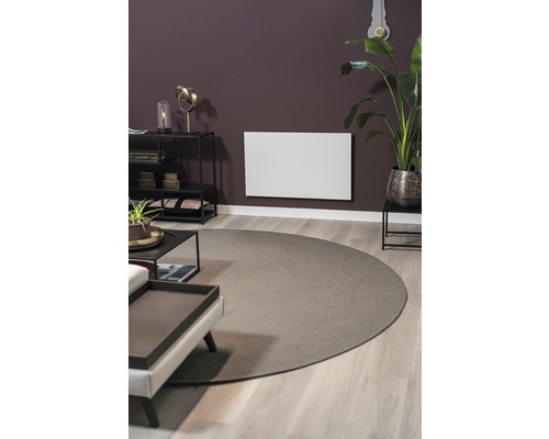 Obývací pokoj s topným panelem na zdi, kobercem a nábytkem.